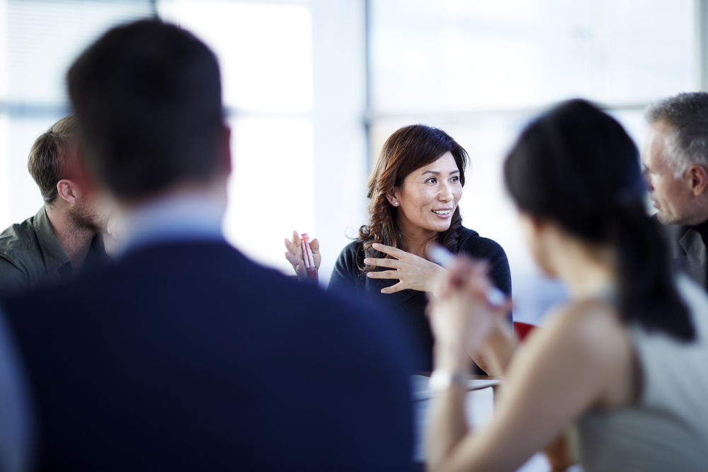 Group of people sitting around desk in a meeting